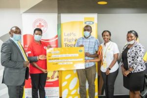 RedCross' Josephine Okwera (2L) and her team, Received the cheque from MTN's Rhona Arinaitwe (2R)