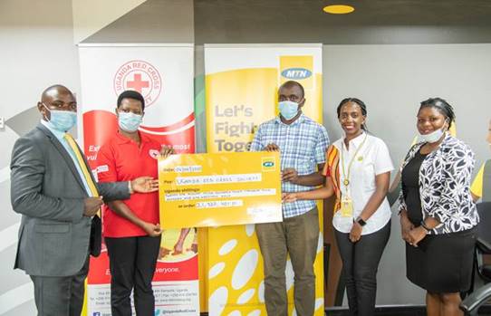 RedCross' Josephine Okwera (2L) and her team, Received the cheque from MTN's Rhona Arinaitwe (2R)