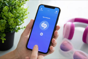 Person-identifying-a-song-using-the-Shazam-app-on-an-iPhone