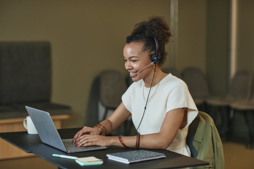 a woman with curly hair working while smiling