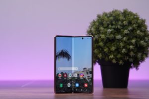 A foldable phone standing on a table. Samsung Galaxy Z Fold 2 standing on a table.
